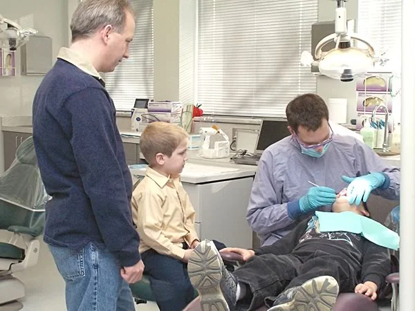 A child observing an older sibling at the dentist: Observational learning occurs at a very young age. Children are more likely to perform the behavior if they like and respect the role model they observe.